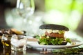 Vegan burger. Black bun, tofu-avocado salad, mayonnaise, cucumber, tomato, fresh salad. Delicious healthy hamburger food