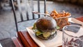 Vegan burger with French fries. Burger with plant based meat cheese. Lunch is on the table. Close-up of a hamburger with cheese on Royalty Free Stock Photo