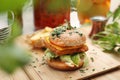 Vegan burger and potato fries on a wooden cutting board, selective focus. Plant-based meal, vege lunch, horizontal view.