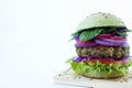 Vegan burger with quinoa and green peas vegetable patty, lettuce, onion, tomato, red cabbage, and spinach isolated on white Royalty Free Stock Photo