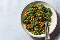 Vegan caesar salad. Fried chickpea salad with kale in white bowl, top view. Vegan food concept