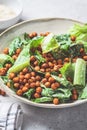 Vegan caesar salad with fried spicy chickpeas in a gray bowl