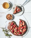 Vegan chocolate almond cake decorated with fresh strawberries and white flowers. A piece of cake on a plate next to a cup of tea. Royalty Free Stock Photo