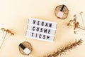 Vegan cosmetics written among bright nude polishes