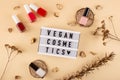 Vegan cosmetics written among bright nude polishes