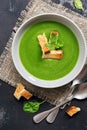 Vegan cream spinach soup with croutons on a dark background. Top view, flat lay Royalty Free Stock Photo