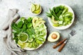 Vegan, detox Buddha bowl with avocado, zucchini noodles, green beans, spiralized cucumber, tomatoes, broccoli, lime and pesto Royalty Free Stock Photo