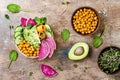 Vegan, detox Buddha bowl recipe with avocado, carrots, spinach, chickpeas and radishes. Top view, flat lay, copy space.
