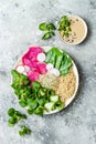 Vegan, detox Buddha bowl recipe with quinoa, snow peas, cucumber, watermelon radish, beet hummus, alfalfa seed sprouts.