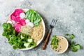 Vegan, detox Buddha bowl recipe with quinoa, snow peas, cucumber, watermelon radish, beet hummus, alfalfa seed sprouts.