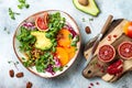 Vegan, detox Buddha bowl with turmeric roasted chickpeas, greens, avocado, persimmon, blood orange, nuts and pomegranate.