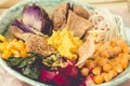 Vegan detox lunch with a purple potato, stewed spinach, and hummus with corn crackers.