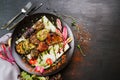 Vegan dish with roasted vegetables on black background