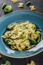 Vegan Farfalle pasta in a spinach sauce with broccoli, brussels sprouts, green beans in plate on dark stone background Royalty Free Stock Photo