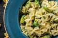 Vegan Farfalle pasta in a spinach sauce with broccoli, brussels sprouts, green beans in plate on dark stone background. Top view Royalty Free Stock Photo