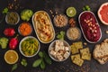 Vegan food background. Vegetarian snacks: hummus, beetroot hummus, green peas dip, vegetables, cereals, tofu. Top view, dark back Royalty Free Stock Photo