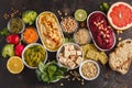 Vegan food background. Vegetarian snacks: hummus, beetroot hummus, green peas dip, vegetables, cereals, tofu. Top view, dark back Royalty Free Stock Photo