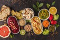 Vegan food background. Vegetarian snacks: hummus, beetroot hummus, green peas dip, vegetables, cereals, tofu. Top view, dark back Royalty Free Stock Photo