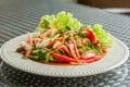 Vegan food concept. Thai hot and spicy mushroom salad with red tomato, sliced carrot, and green lettuce in a white plate Royalty Free Stock Photo