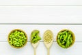 Vegan food with green soybeans or edamame in spoon and bowl on white wooden background top view copy space Royalty Free Stock Photo