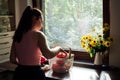 Vegan food and health. Vegans Eat. Young Latina woman holding red Bell pepper near vegetables on table in home kitchen. Royalty Free Stock Photo