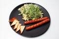 Vegan food. Salad, tofu and plant based sausages in black plate on white Royalty Free Stock Photo