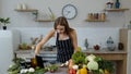 Vegan girl cooking salad with raw vegetables while looking on digital tablet for online recipe