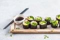 Vegan green sushi rolls with avocado, sprouts, cucumber and nori on a wooden board