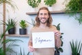 Happy man holding poster with word vegan