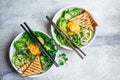 Vegan lunch - buddha bowl with zucchini pasta, grilled tofu, guacamole, sweet potato hummus and vegetables, gray background, top Royalty Free Stock Photo