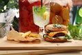 Vegan lunch set. Vege burger, potato fries and lemonade on a wooden cutting board. Plant-based meal, horizontal view.