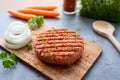 Vegan meatless burger, raw plant-based meat on a cutting board with vegetables Royalty Free Stock Photo