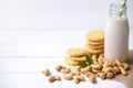 Vegan milk from cashews in bottles and cashew nut cookie on white wooden surface, Cashew nuts is used in most indian sweets