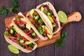 Healthy vegan mushroom tacos. Serving board, above view on a dark wood background.