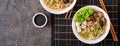 Vegan noodle soup with tofu cheese, shiitake mushrooms and lettuce in white bowl. Asian food. Top view. Banner. Flat lay