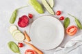 Vegan, organic, healthy food, plant-based diet concept. White plate on the table among vegetables and fruits close up Royalty Free Stock Photo