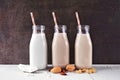 Vegan, plant based, non dairy milk in milk bottles with scattered ingredients