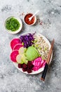 Vegan poke bowl with avocado, beet, pickled cabbage, radishes. Top view, overhead, flat lay.
