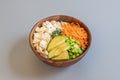 Vegan poke bowl recipe with tofu tacos, ripe avocado pieces, edamame beans with salt and filleted carrot