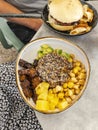 Healthy quinoa poke bowl and a vegan burger with yuka chips Royalty Free Stock Photo