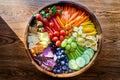 Vegan rainbow bowl with peppers, berries, grapes, cucumber, pineapple, celery, vegan cheese