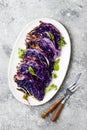 Vegan roasted red cabbage steaks on grey concrete background. Top view, flat lay.