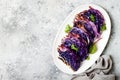 Vegan roasted red cabbage steaks on grey concrete background. Top view, flat lay.