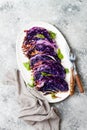 Vegan roasted red cabbage steaks on grey concrete background. Top view, flat lay.
