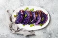Vegan roasted red cabbage steaks on grey concrete background. Top view, flat lay.