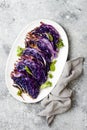 Vegan roasted red cabbage steaks on grey concrete background. Top view, flat lay.