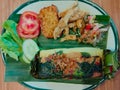 Vegan roasted rice is rice seasoned with vegan spices and side dishes, then wrapped in banana leaves