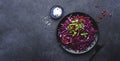 Vegan salad with red cabbage, parsley, pomegranate seeds, sunflower sprouts and olive oil dressing on black kitchen table Royalty Free Stock Photo