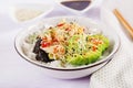 Vegan salad with rice, pickled kimchi cabbage, avocado, nori and sesame on bowl.