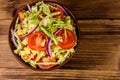 Vegan salad with savoy cabbage, tomatoes and onion in a ceramic bowl. Top view Royalty Free Stock Photo